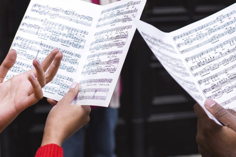 high-angle-people-holding-sheets-music
